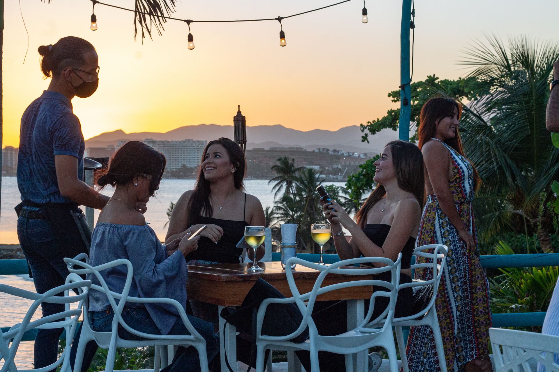Un grupo de mujeres está sentada en una mesa con copas de vino en Guayoyo Gastro Bar.
