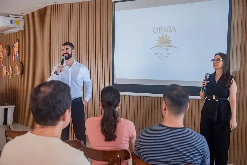 Uma grande sala de jantar com mesas e cadeiras e pratos.