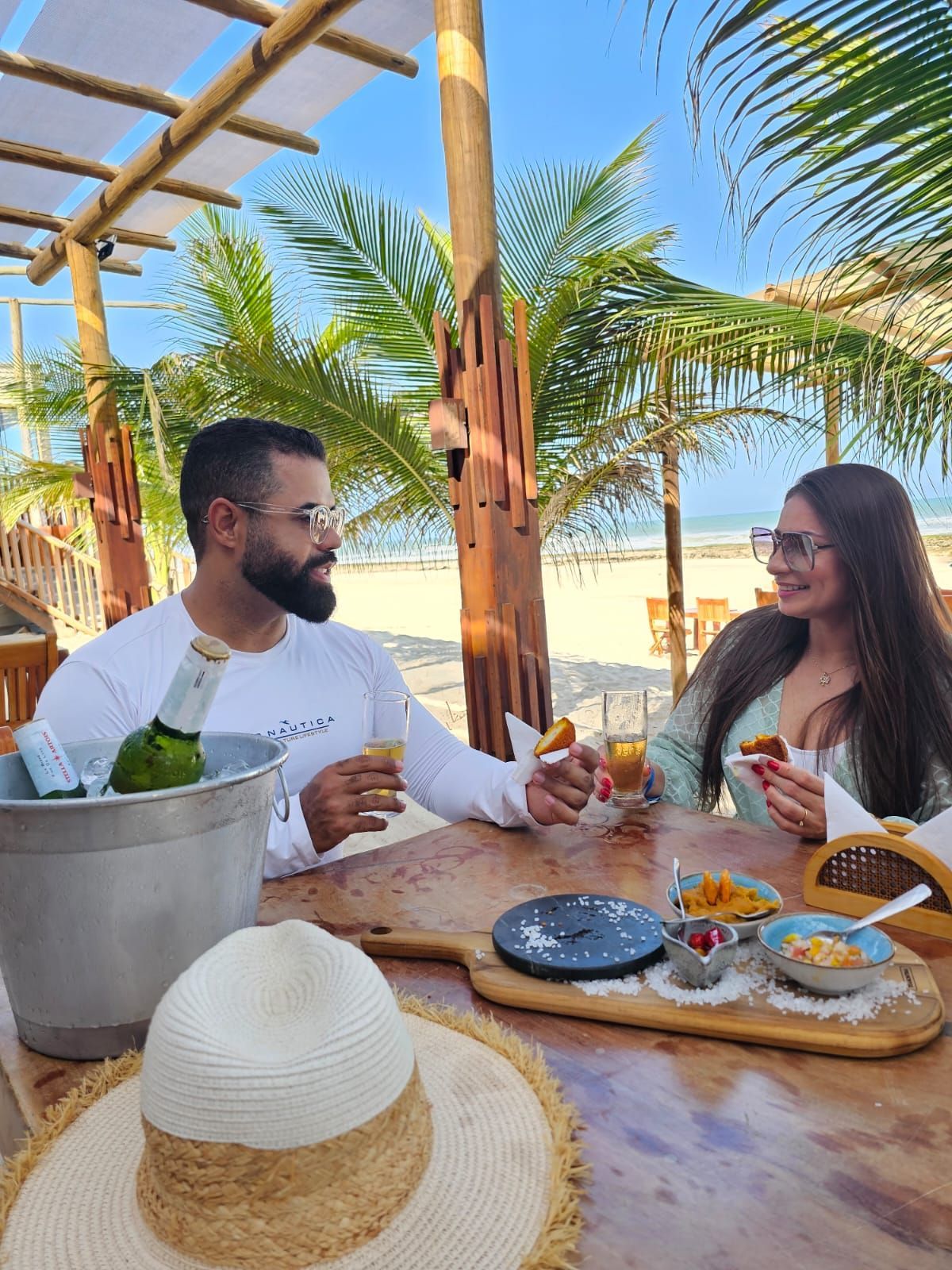 Um homem está servindo comida para uma mulher e um homem em um restaurante.