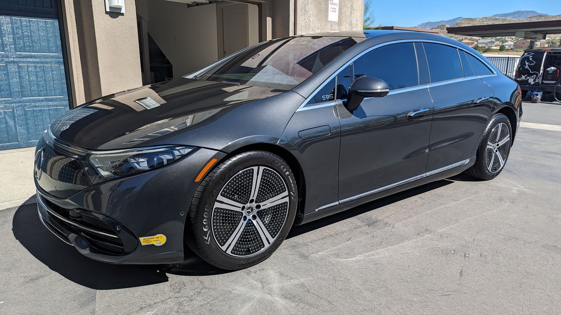 Black sedan parked outside a building on a sunny day