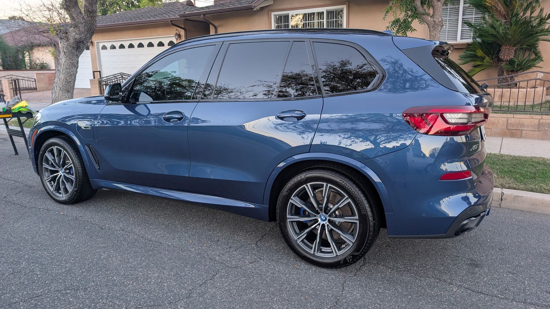 Blue SUV parked on a residential street in front of a house