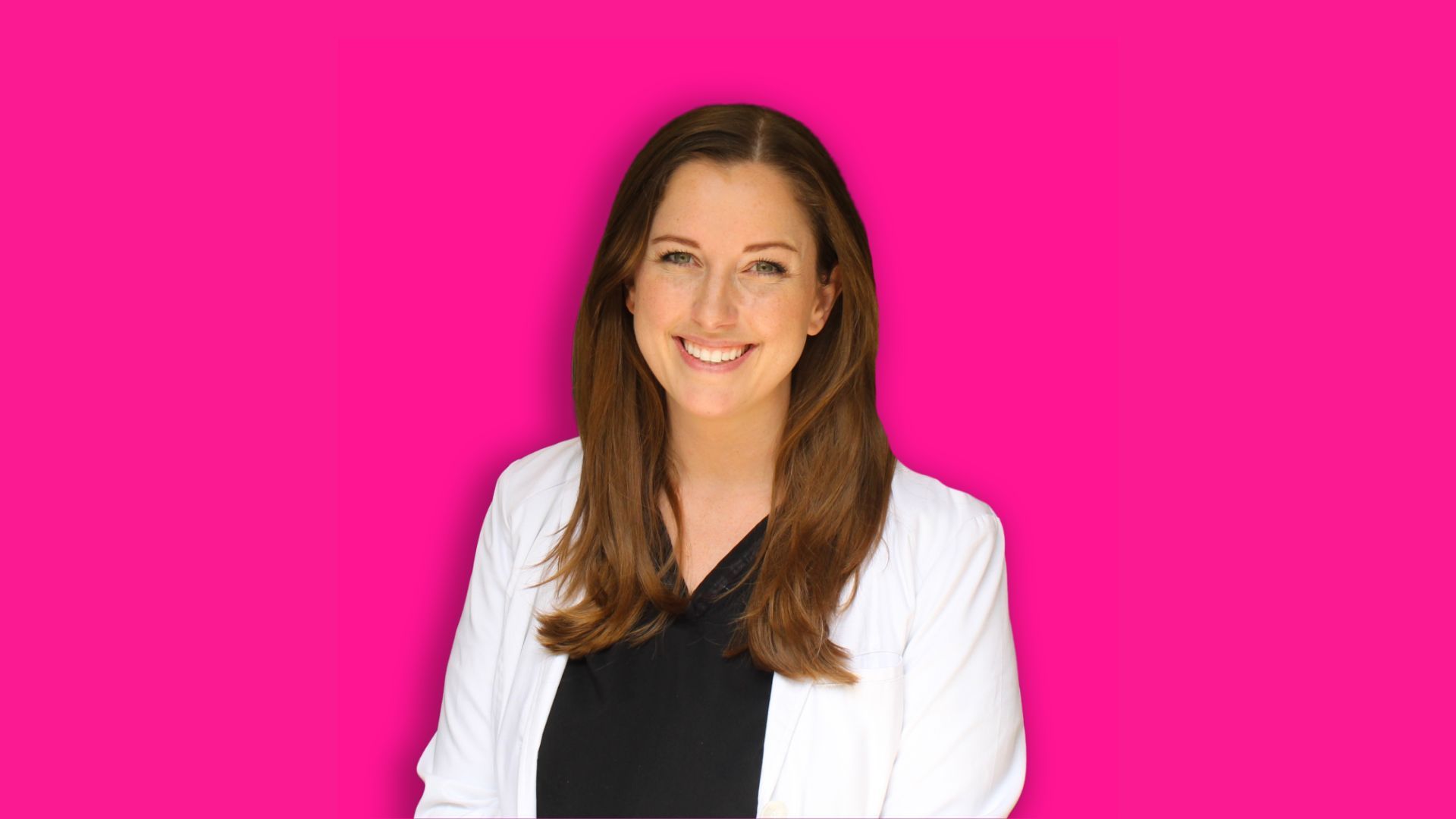 A woman with long brown hair, wearing a white blazer and black top, smiling against a vibrant pink background.