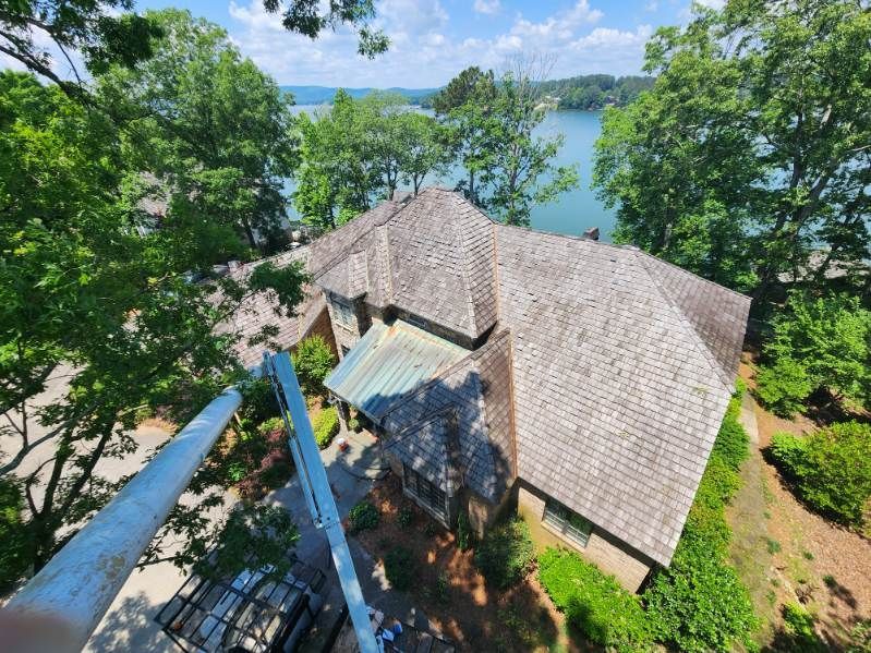 An aerial view of a large house with a lake in the background.