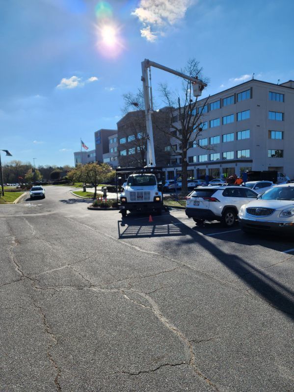 A white truck is parked in a parking lot in front of a building.