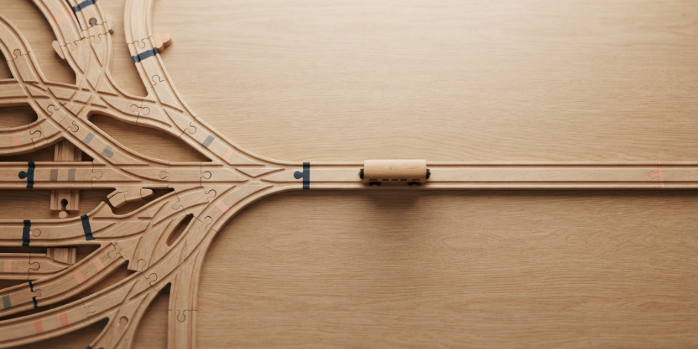 Wooden cable organizer with carved slot and coiled cord on a light wood surface
