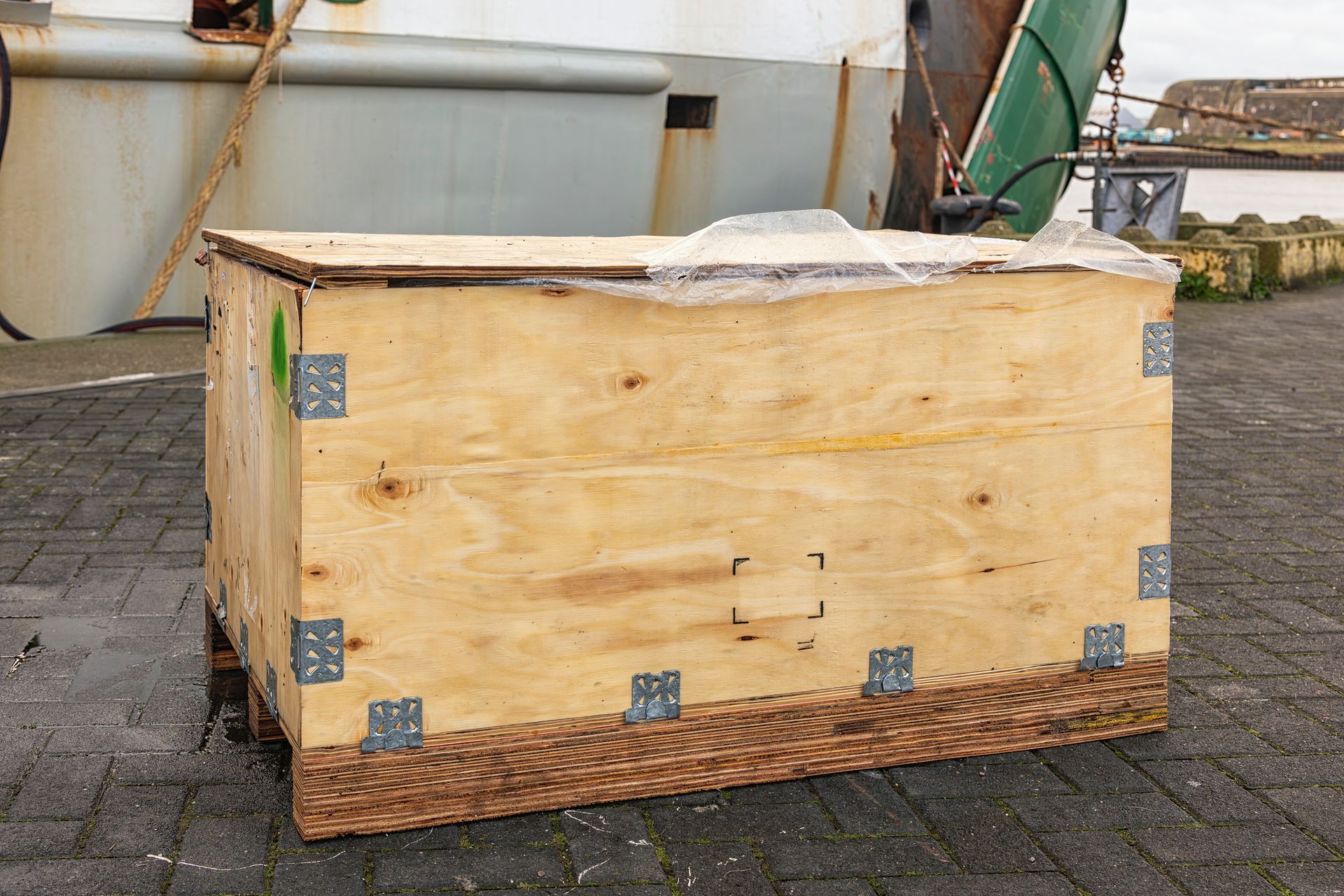 View of a wooden crate with metal fittings in the outdoors.