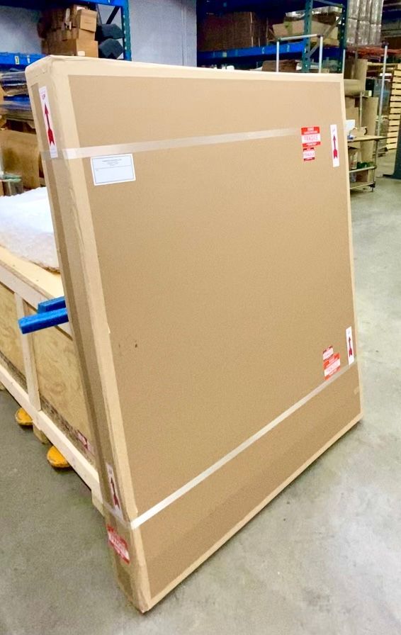 A Commerce Packaging-constructed double-wall corrugated carton containing the painting, which is still boxed up in foam and wrapped in wrapping paper inside the corrugated carton