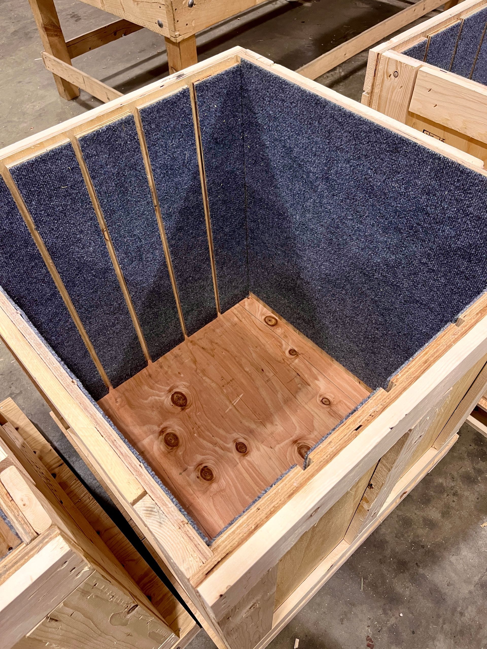 A view of a crate meant to hold 4 felt-lined partitions with the partitions removed, showing the bottom (without polyethylene foam added yet), felt-lined sides, and gaps left for the partitions to slot into