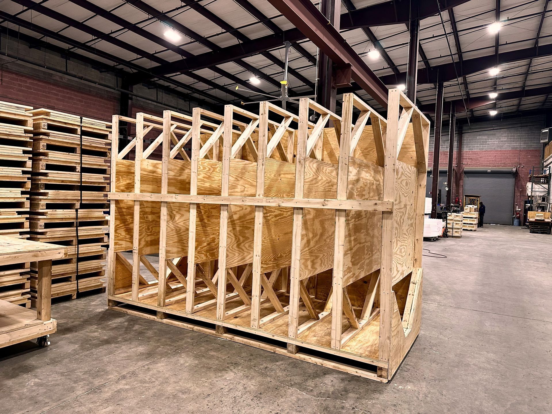 Wooden crate, built on a pallet, inside a warehouse, used for shipping.