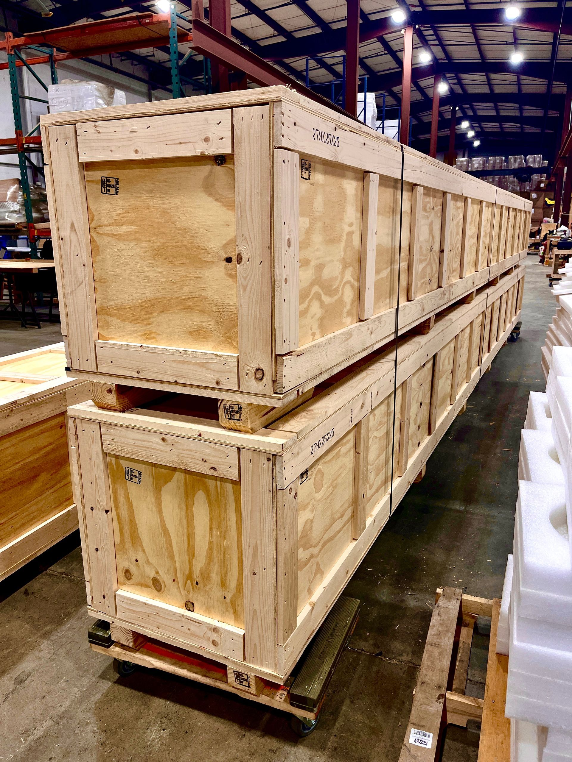 Two stacked wooden crates on pallets in a warehouse.
