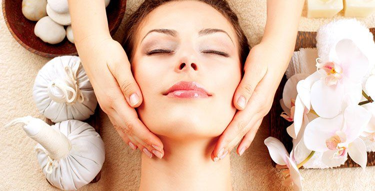 Eine Frau bekommt in einem Spa eine Gesichtsmassage.