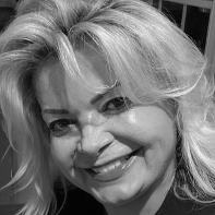 Woman with blonde hair smiling, close-up shot.