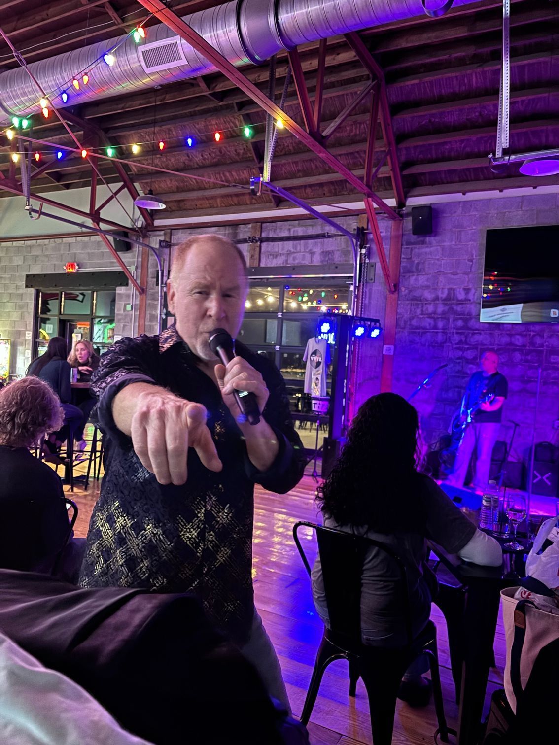 Phil singing and pointing at camera