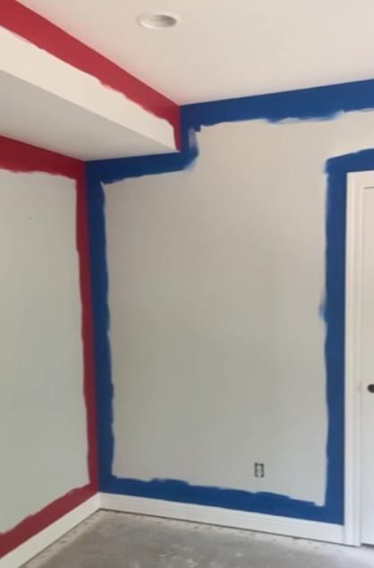 a woman paints a wall next to a ladder and a bucket of paint