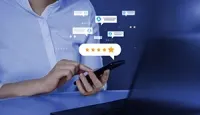 Hands using a smartphone to give a five-star rating, surrounded by digital social media message icons.