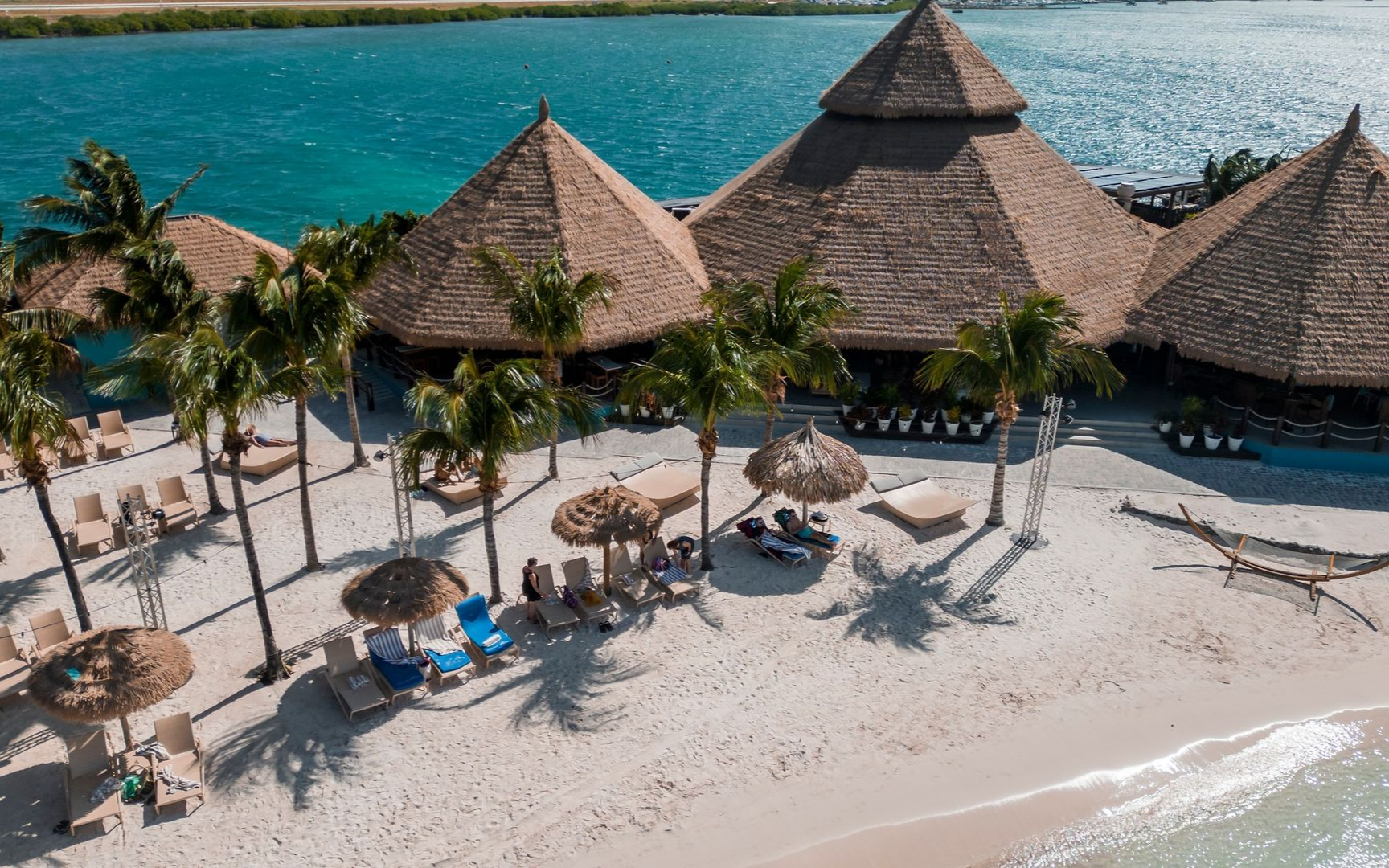 An aerial view of a beach with white sand and turquoise water.