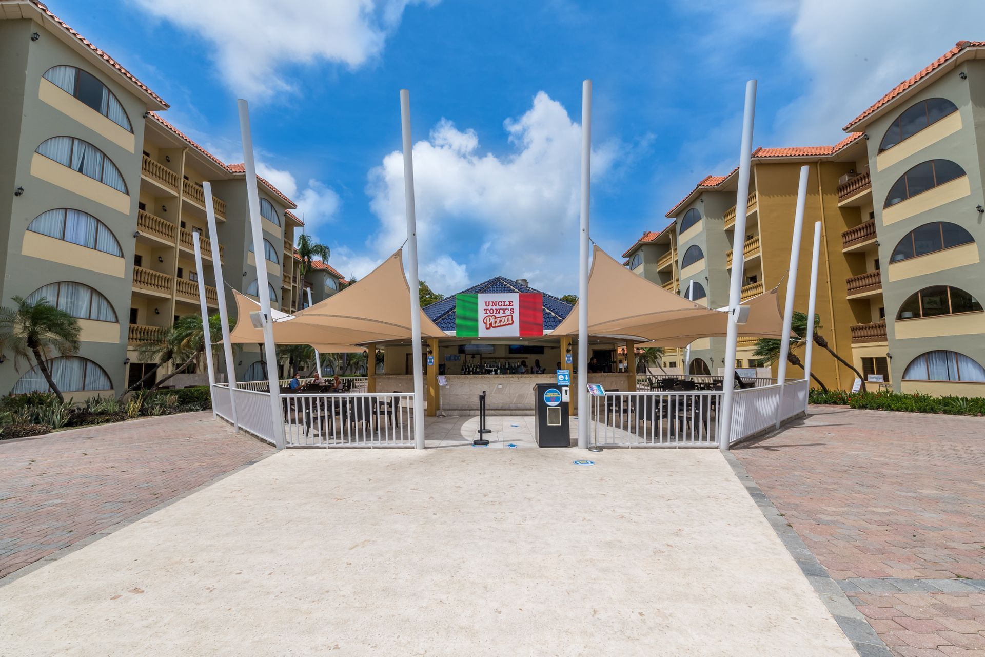 A large tent with a mexican flag on it is in front of a building.