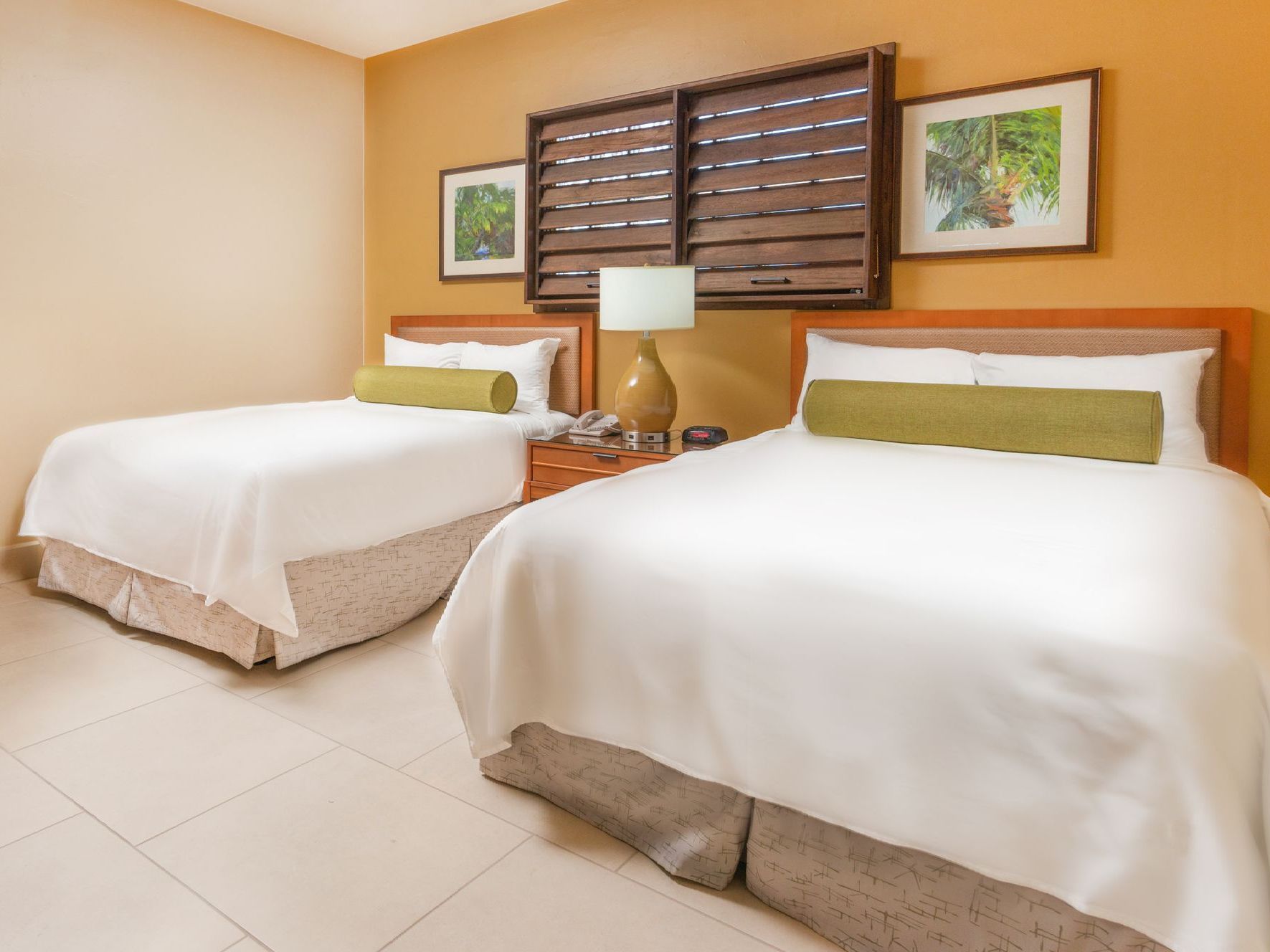 A hotel room with two beds and a lamp