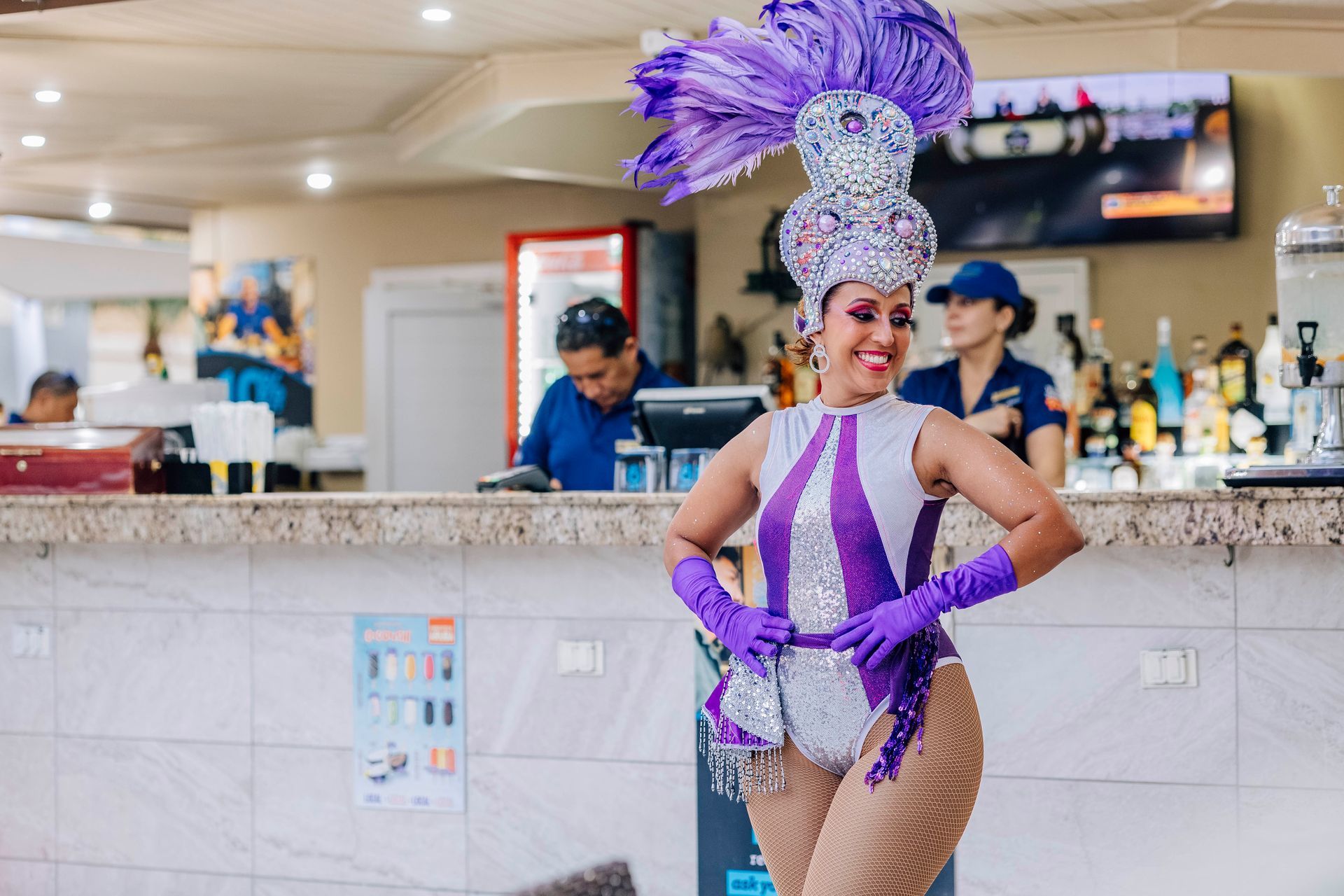 Woman in vibrant purple costume poses at a bar.