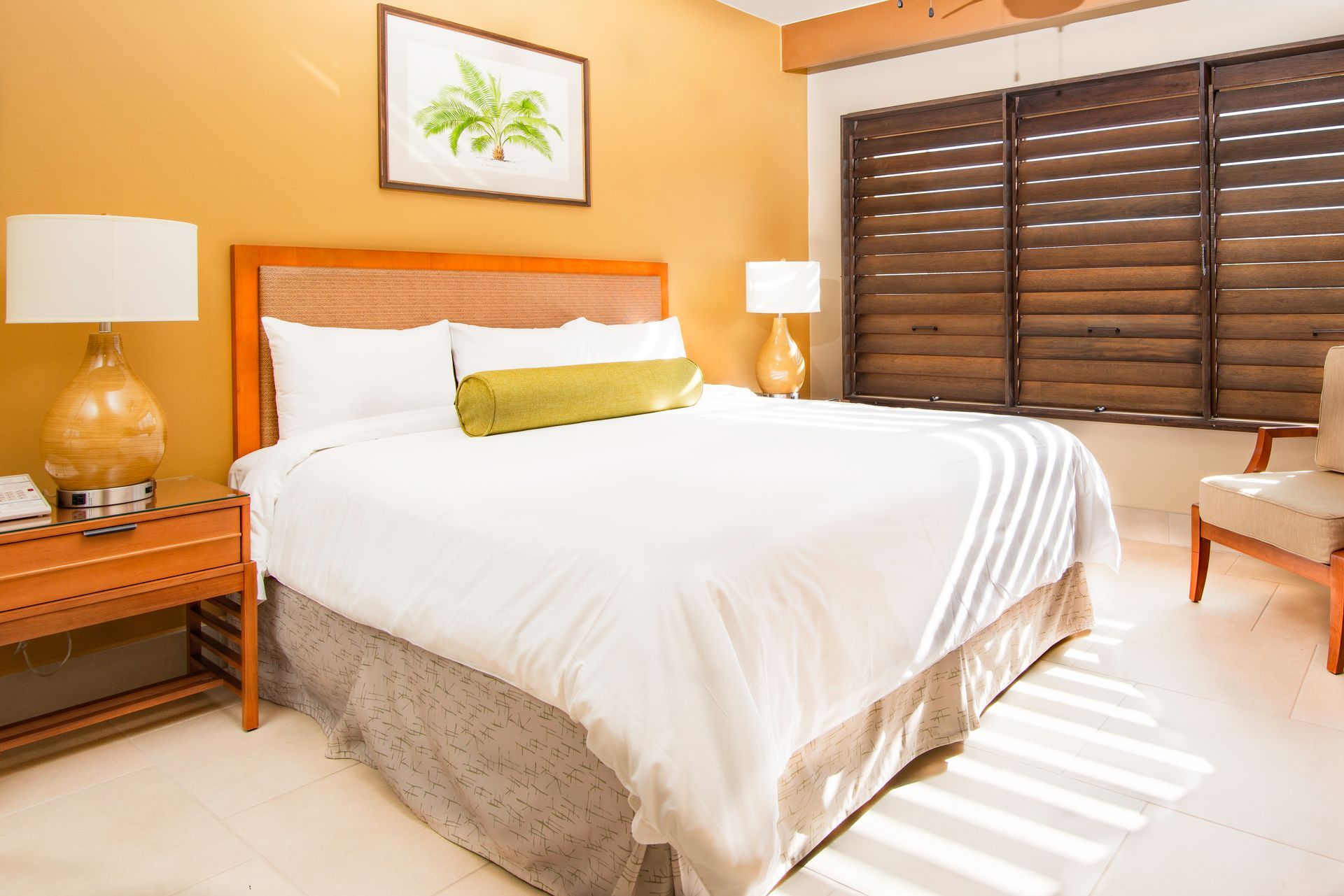 A hotel room with a king size bed and a chair.
