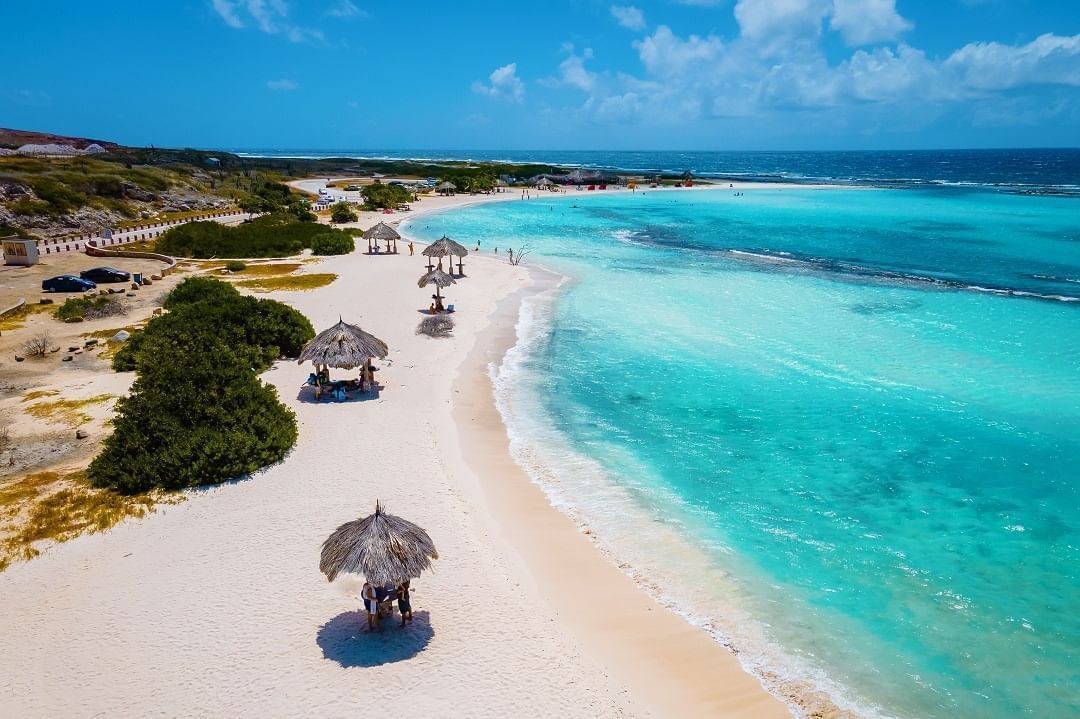 An aerial view of a beach with white sand and turquoise water.