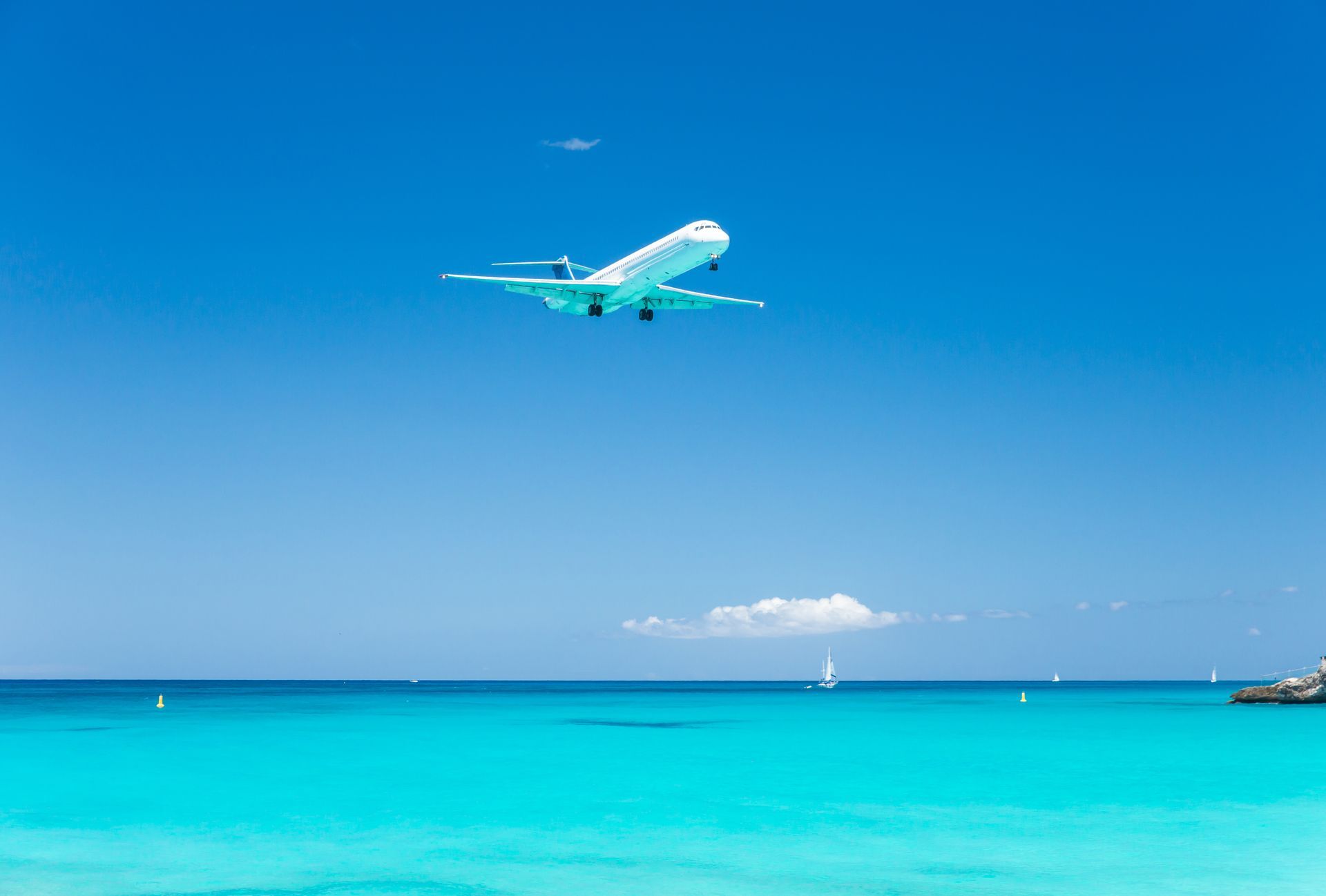 An aerial view of a beach with white sand and turquoise water.