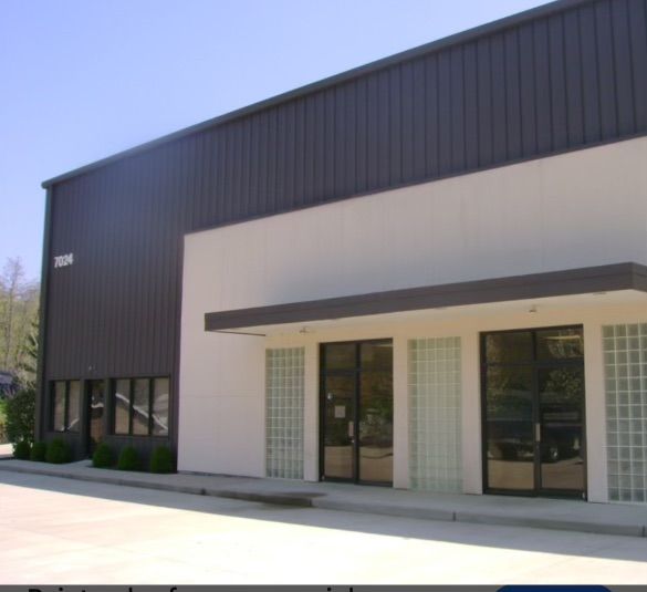 A white building with a brown roof and a sign that says ' a ' on it