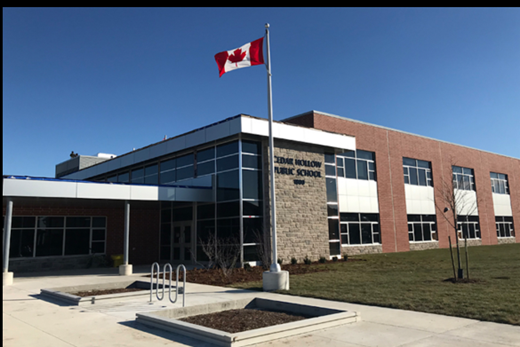 A canadian flag is flying in front of a large building