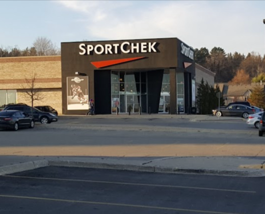 A sportchek store with cars parked in front of it