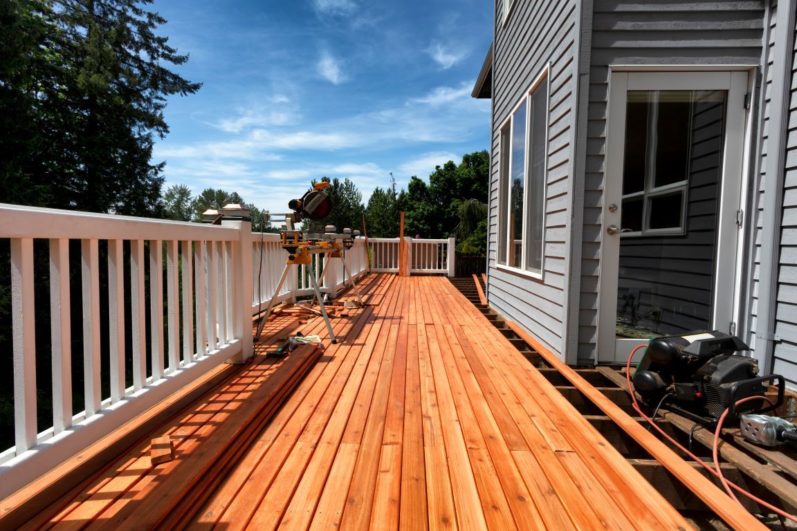 A wooden deck is being built on the side of a house.