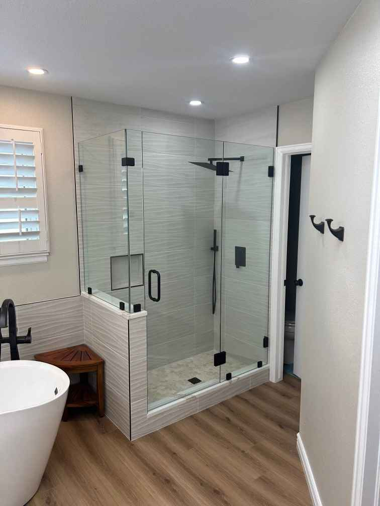A bathroom with a walk in shower and a bathtub.