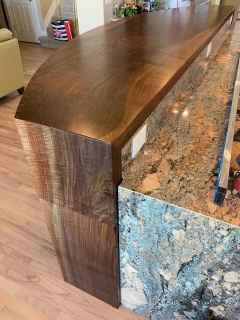 A kitchen counter with a wooden top and a granite counter top.