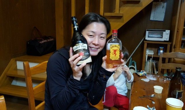 Japanese woman holding bottles of Canadian Fireball Whisky and Cabot Trail Maple Cream.
