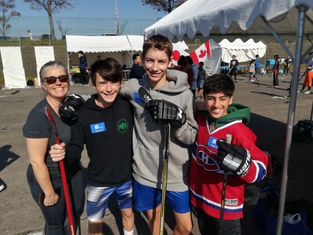 Three youths (and a mom) enjoying a Canadian street hockey event in Kariya, Japan.