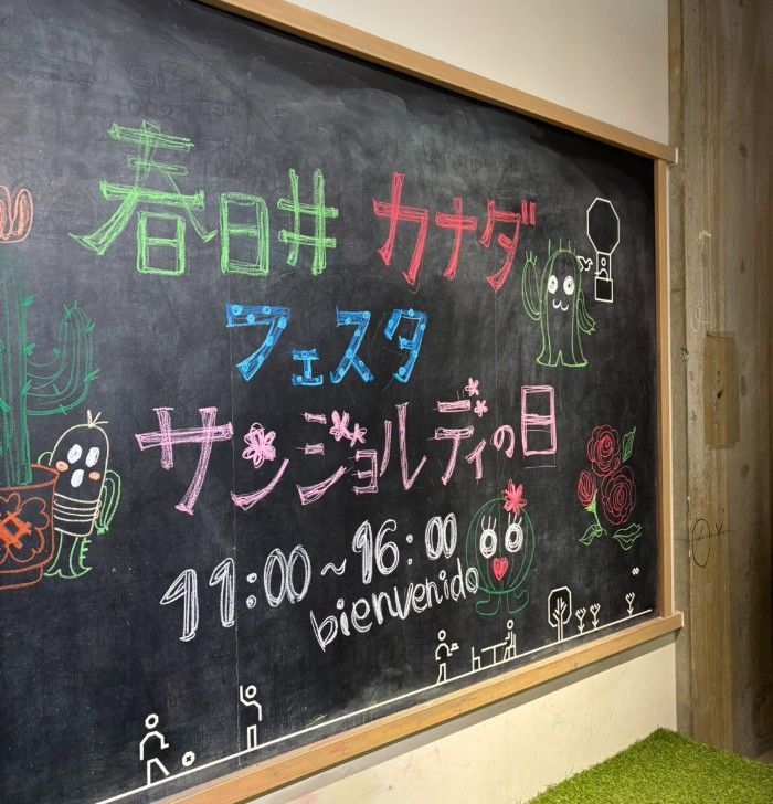 Chalkboard sign for a Canada festival in Kasugai. Includes Japanese text, colorful drawings, and hours: 11:00-16:00.