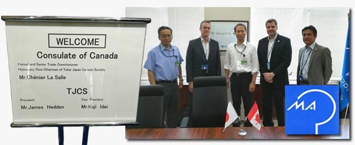 Welcome sign for the Consulate of Canada. Five men standing behind a table, with flags of Canada and Japan.