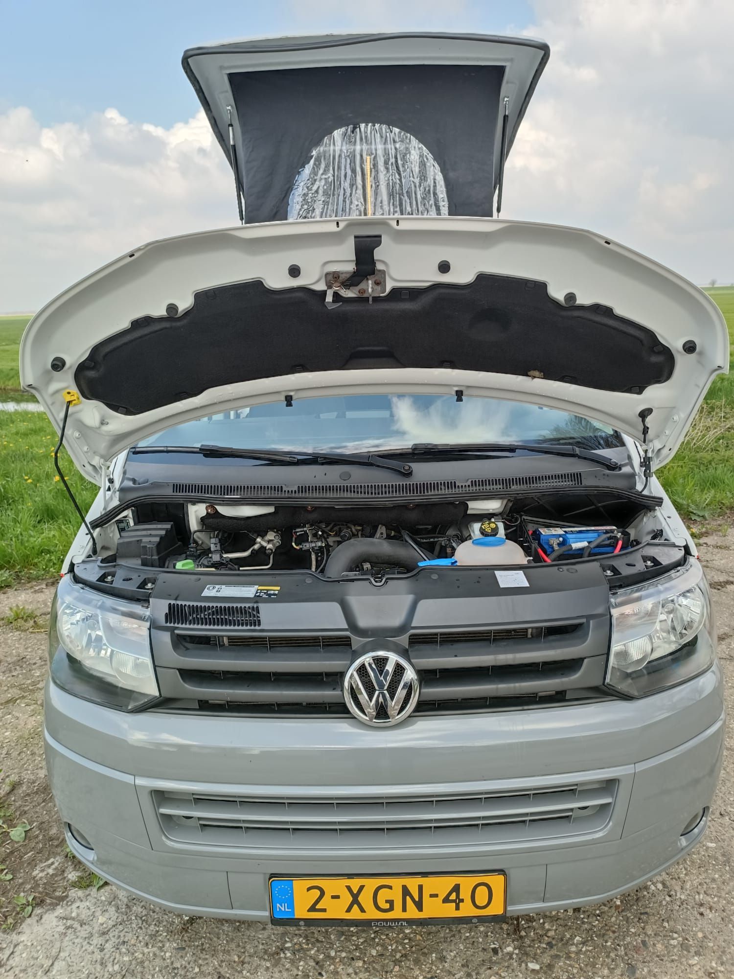 Grijze camper met open kap en dak, kenteken 