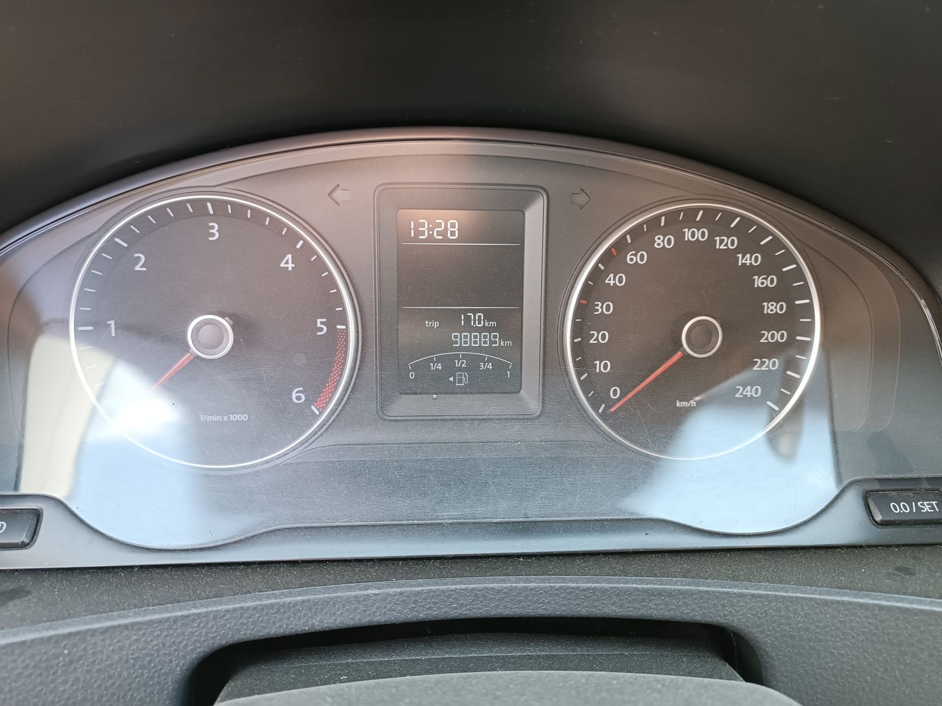 Autodashboard met snelheidsmeter, toerenteller en digitaal display met de tijdsaanduiding 12:28.