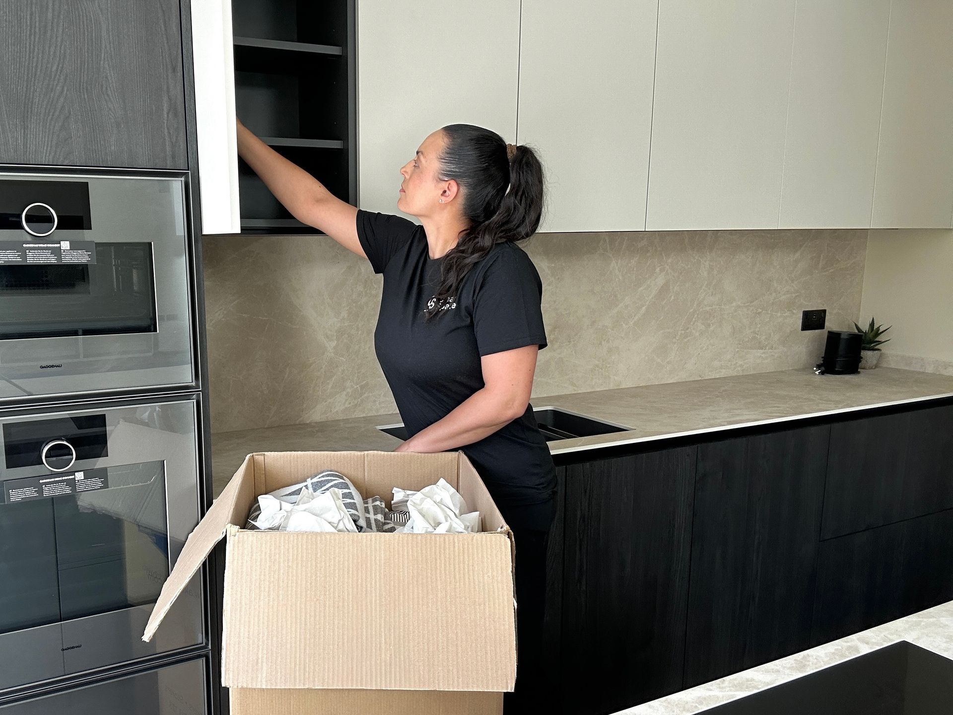 Home organiser unpacking and arranging kitchen storage