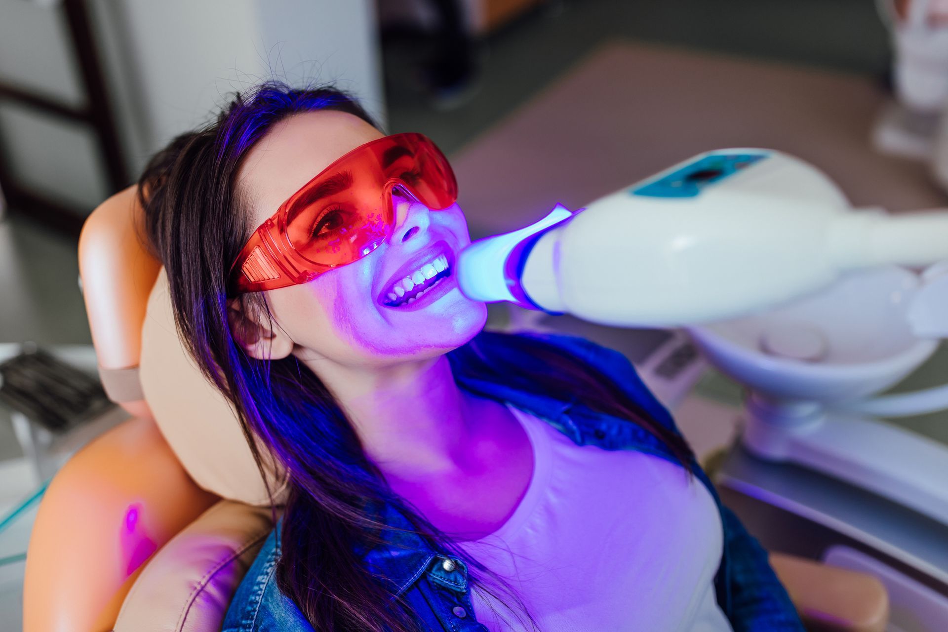 A woman is getting a teeth whitening procedure. A woman is getting a teeth whitening procedure.