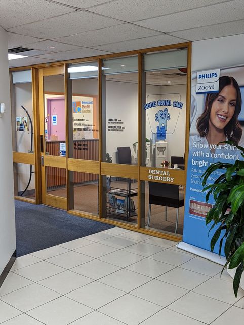 Entrance to an eye care office with glass panels.  A person in a banner advertises the office.