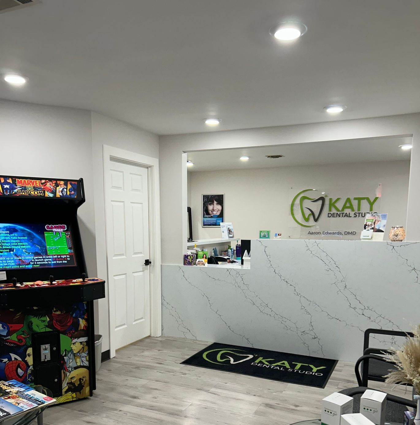 A dental office with a arcade machine and a reception desk