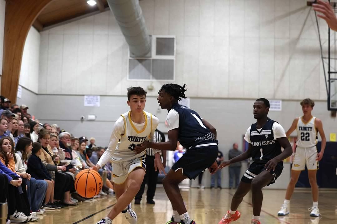 Basketball game in a gym, players battling for the ball near the sideline.