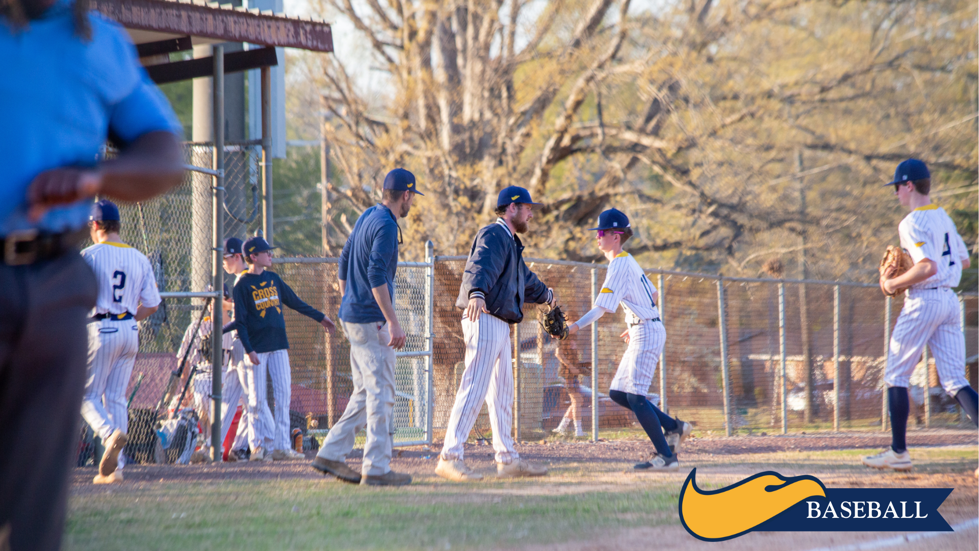 Youth baseball players warming up on a field, with trees and a Nike Baseball logo in the corner.