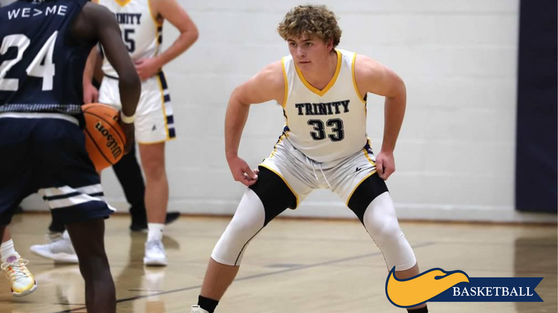 Basketball player in white jersey #33 crouches defensively on the court during a game