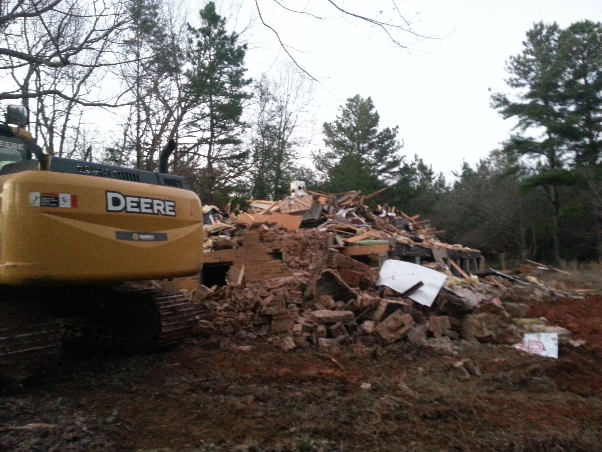 Yellow John Deere Excavator Clearing Rubble