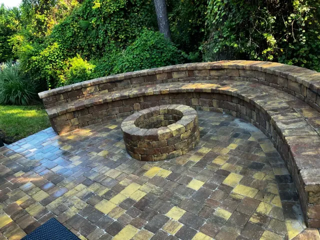 Tremron Autumn Blend paver patio with curved retaining wall and fire pit in Jacksonville, FL