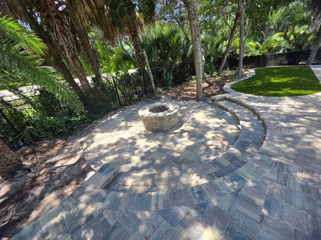 Paver patio with drop-down fire pit and inset artificial turf in St. Augustine, FL