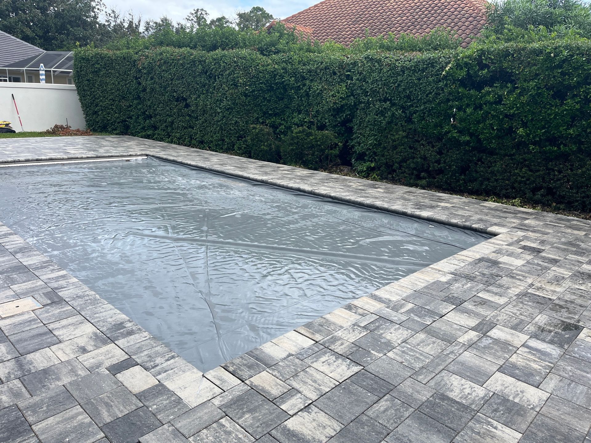 Gray paver patio with water pooling, installed by Outdoor Transformations in Butler Beach, FL.