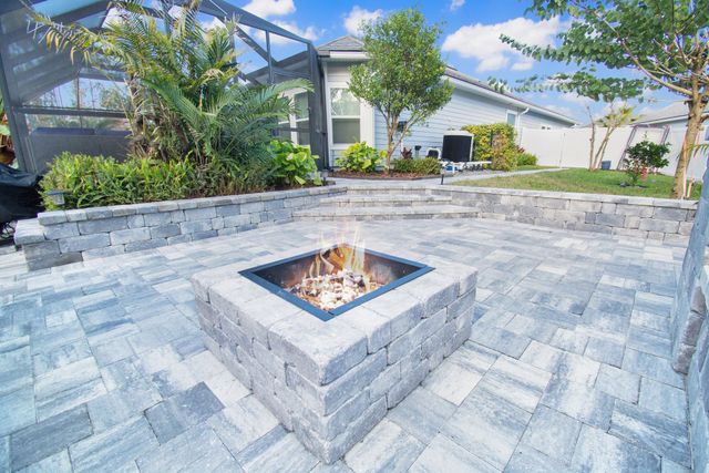 Gray paver patio with built-in benches and square fire pit in St. Johns, FL